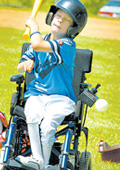 Child in wheelchair hitting ball